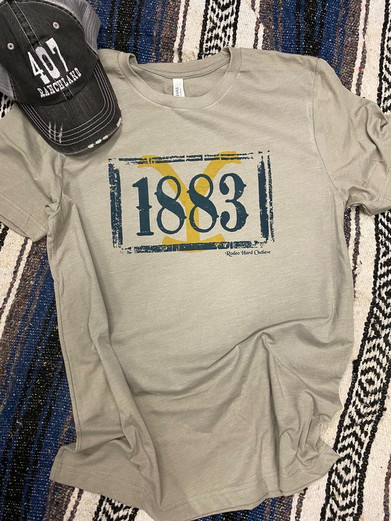 Beige unisex jersey short-sleeve tee with 1883 graphic print and yellow accent.